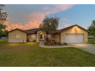 Charming single-story home with a well-manicured lawn and attached two-car garage at sunset at 6701 Nw 6Th Ave, Ocala, FL 34475
