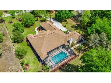Expansive aerial view of a home with a screened-in pool and well-maintained landscaping at 18498 Sw 69Th Loop, Dunnellon, FL 34432