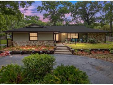 Charming single-story home with stone accents, landscaped garden beds, and a welcoming front porch at 4085 Se 23Rd Ter, Ocala, FL 34480