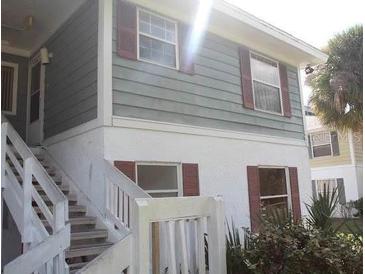 Charming exterior showcasing a two-story building with white stairs and red shutters at 8142 Fairways Cir # S204, Ocala, FL 34472