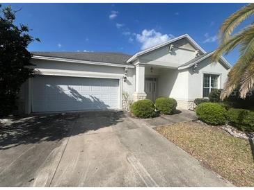 Inviting single-Gathering home features a well-maintained lawn and a convenient two-car garage at 1703 Sanderling St, The Villages, FL 32162