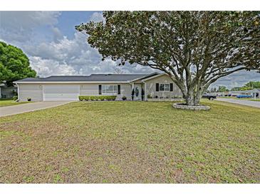 Charming single-story home with a well-maintained lawn and mature landscaping at 17475 Se 107Th Ct, Summerfield, FL 34491