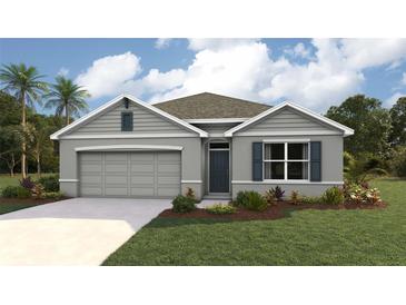 Charming single-story home featuring a two-car garage, well-manicured lawn, and neatly landscaped greenery at 373 Hickory Course Trl, Ocala, FL 34472