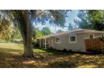 Charming single-story home featuring a covered porch and a mature tree providing shade at 1858 Se Lake Weir Ave, Ocala, FL 34471