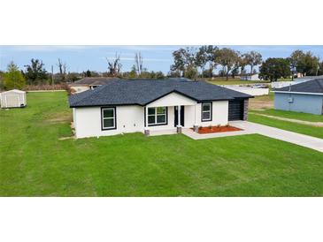 Charming single-story home with a well-manicured lawn and a contrasting black and white color scheme at 1062 Nw 69Th St, Ocala, FL 34474
