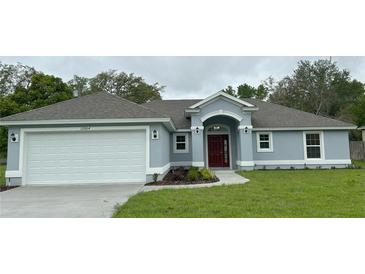 Charming single-story home with a well-manicured lawn and a two-car garage at 12864 Sw 40 Ter, Ocala, FL 34473