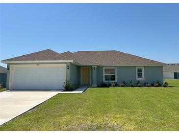 Charming single-story home with a well-manicured lawn and an attached two-car garage at 3474 Sw 155Th Pl, Ocala, FL 34473