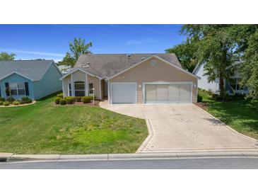 Charming single-story home featuring a two-car garage and well-maintained landscaping at 710 Antonia Ln, The Villages, FL 32159