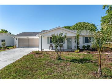 Charming single-story home with a well-manicured lawn and screened two-car garage at 8851 Sw 116Th Street Rd, Ocala, FL 34481