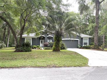 Charming single-story home featuring a manicured lawn and mature trees at 18956 Sw 93Rd Loop, Dunnellon, FL 34432