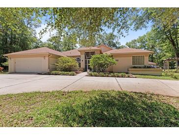 Sprawling single story home featuring mature landscaping, long driveway and attached two car garage at 21884 Sw 88Th Lane Rd, Dunnellon, FL 34431
