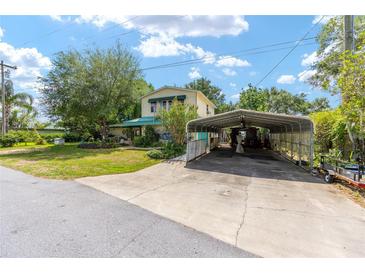 Charming two-story home with a large covered carport and a well-manicured lawn at 31 Se Chinica Dr, Summerfield, FL 34491