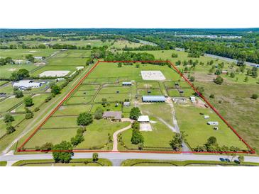 Expansive aerial view of a horse farm with paddocks, barns, riding arena, and residence, all within a clearly defined perimeter at 5415 Nw 100Th St, Ocala, FL 34482
