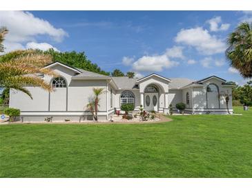 Beautiful one-story home with a well-manicured lawn, fresh landscaping and a welcoming double-door entrance at 5819 Ne 72Nd St, Silver Springs, FL 34488