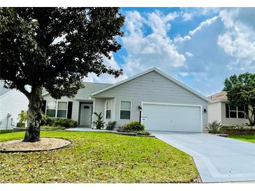 Charming single-story home with a well-manicured lawn and an attached two-car garage at 7474 Se 172Nd Fieldcrest St, The Villages, FL 32162