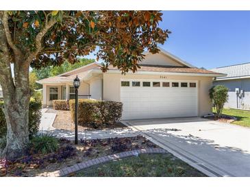 Charming single-story home with a well-manicured lawn, mature trees, and an attached two-car garage at 9541 Sw 93Rd Loop, Ocala, FL 34481