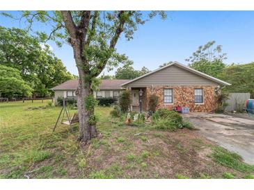 Ranch home with stone facade, mature landscaping, and a charming porch swing for relaxing outdoors at 10575 Sw 27Th Ave, Ocala, FL 34476