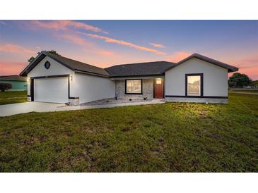 Charming single-story home with a well-maintained lawn and a welcoming red front door at 12 Bahia Pass Ter, Ocala, FL 34472