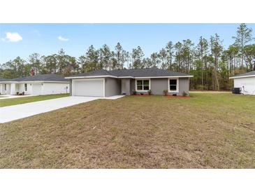 Charming single-story home featuring a well-maintained lawn, attached garage, and neutral paint scheme at 15071 Sw 16 Pl, Ocala, FL 34481
