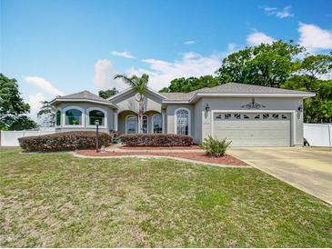 Charming single-story home featuring a two-car garage, manicured lawn, and a well-maintained landscape at 4033 Ne 15Th Court Rd, Ocala, FL 34479