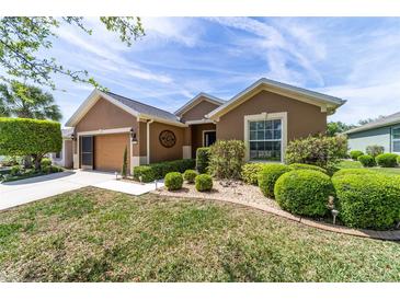 Beautifully landscaped front yard of a charming single-story home with a well-manicured lawn and shrubbery at 7432 Sw 98Th Ave, Ocala, FL 34481