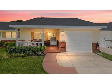 Charming single-story home with a covered front porch, attached garage, and well-maintained lawn at 8625 Sw 94Th Ln # D, Ocala, FL 34481