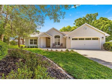Charming single-story home with a well-manicured lawn and inviting curb appeal on a sunny day at 8750 Sw 108Th St, Ocala, FL 34481