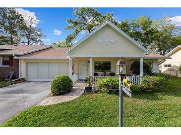 Charming home with a manicured front yard, inviting porch, and attached garage provides curb appeal at 8833 Sw 98Th Street Rd # E, Ocala, FL 34481