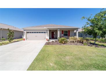 Charming home featuring a well-maintained front yard, two-car garage and a welcoming front porch at 10033 Sw 96Th St, Ocala, FL 34481