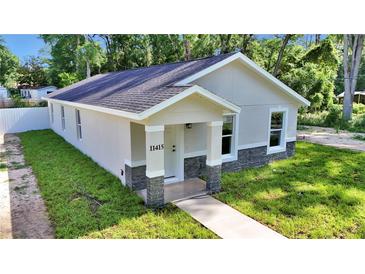 Charming single-story home with a covered entry, featuring stone accents and fresh landscaping at 11415 Nw 15Th St, Ocala, FL 34482