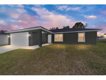 Charming single-story home with an attached two-car garage and a well-manicured lawn at 4073 Se 136Th Pl, Summerfield, FL 34491