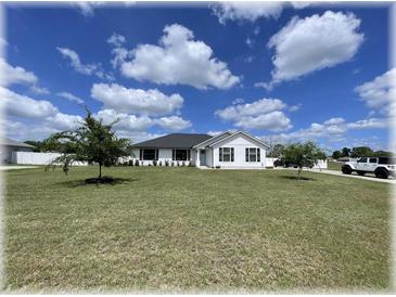 Charming single-story home with a well-manicured lawn, blue front door, and inviting curb appeal at 6365 Se 12Th Ln, Ocala, FL 34472