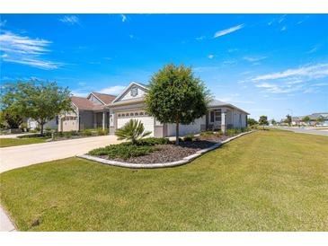 Landscaped front yard with a well-maintained lawn and inviting curb appeal enhances this charming single-story home at 7696 Sw 86Th Ct, Ocala, FL 34481
