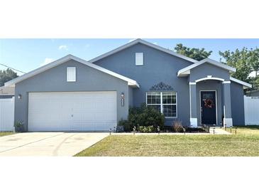 Charming single-story home featuring a well-manicured lawn and a two-car garage at 8004 Juniper Rd, Ocala, FL 34480