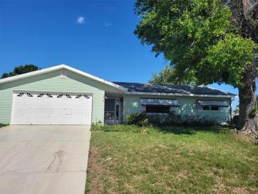 Charming one-story home with an attached garage, lush lawn, and mature trees enhancing its curb appeal at 11053 Sw 78Th Ct, Ocala, FL 34476