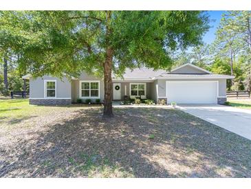 Charming single-story home with stone accents, a two-car garage, and a well-manicured front lawn at 13164 Sw 78Th Place, Dunnellon, FL 34432