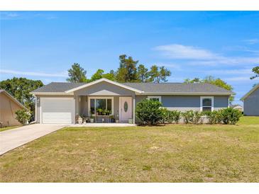 Charming one-story home with a well-manicured front yard, inviting entrance, and attached garage at 2705 Sw 156Th Lane Rd, Ocala, FL 34473