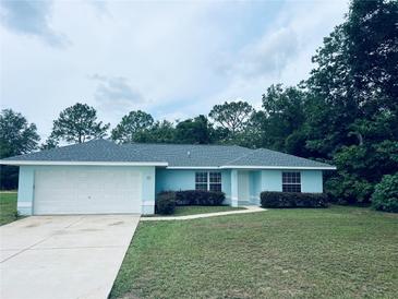 Charming one-story home featuring an attached two-car garage and manicured landscaping at 38 Laurel Ct, Ocala, FL 34480