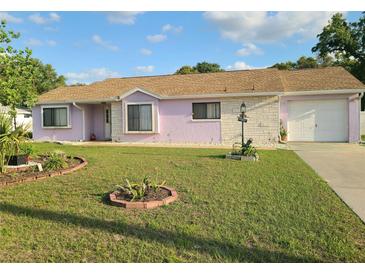Charming single-story home with a well-maintained lawn and inviting curb appeal under a blue sky at 5606 Sw 107Th St, Ocala, FL 34476