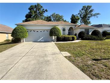 Charming single-story home with a well-maintained lawn, a two-car garage, and manicured landscaping at 7421 Sw 110Th Pl, Ocala, FL 34476