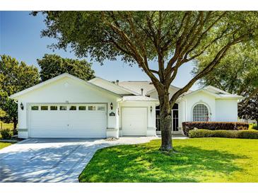 Charming one-story home featuring a three-car garage, well-maintained lawn, and mature landscaping at 1763 Sw 155Th Place Rd, Ocala, FL 34473