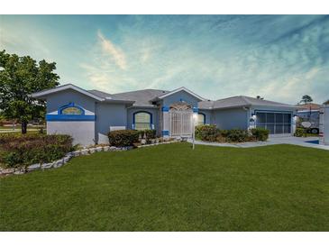 Charming single-story home with manicured lawn and blue trim, offering great curb appeal at 4085 Sw 110Th St, Ocala, FL 34476