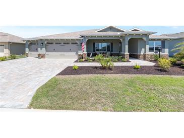 Charming single-story home with a well-manicured lawn, three-car garage, and inviting front porch at 9573 Sw 79Th Loop, Ocala, FL 34481