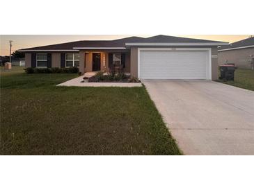 Charming single-story home with a well-maintained lawn and a two car attached garage at 12840 Sw 60Th Ct, Ocala, FL 34473