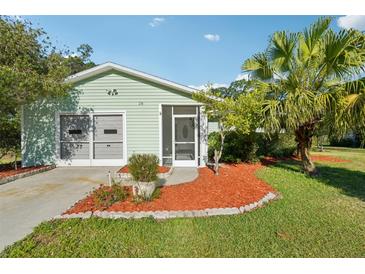 Charming single-story home with a well-manicured lawn, mature landscaping, and a cozy screened-in porch at 28 Gordon Ct, Leesburg, FL 34788