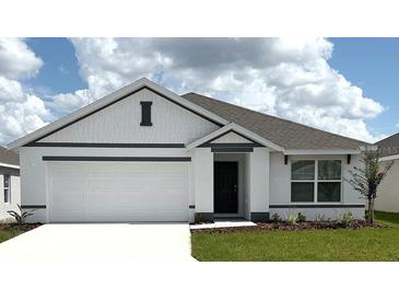 Charming single-story home with a well-maintained lawn and a two-car garage at 4730 Sw 88Th Ln, Ocala, FL 34476