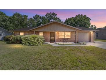 Charming brick home featuring a well-maintained lawn and inviting front porch at 5720 Se 22Nd Pl, Ocala, FL 34480