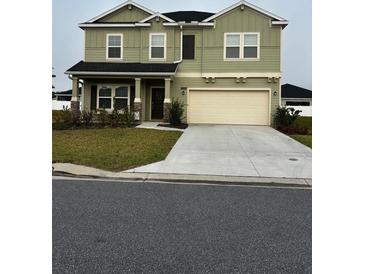 Two-story home featuring a two-car garage, neutral color palette, and well-maintained landscaping at 9326 Sw 57Th Ter, Ocala, FL 34476