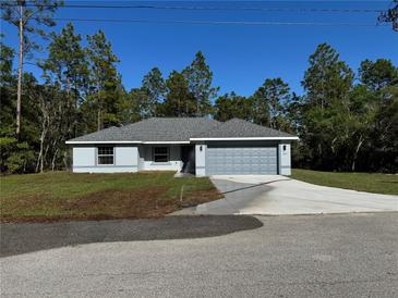 Charming single-story home featuring a well-manicured lawn and an attached two-car garage at 952 Sw Willow Rd Ext, Dunnellon, FL 34431