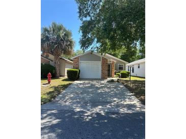 Cozy single-Gathering home featuring an attached two-car garage and mature landscaping at 2127 N.E. 40Th Ave., Ocala, FL 34470